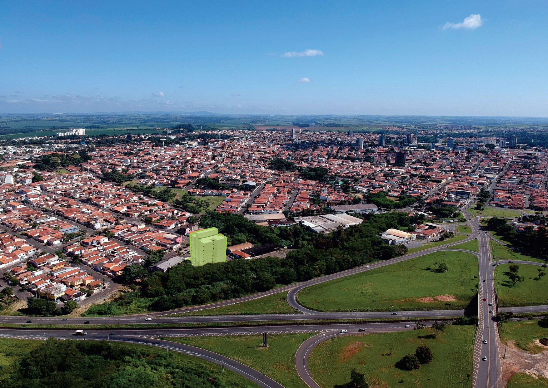 Vista aérea de Santa Bárbara d'Oeste com a torre do Edifício Victoria destacada em verde ao lado da Rodovia Luís de Queiroz, com a cidade ao fundo